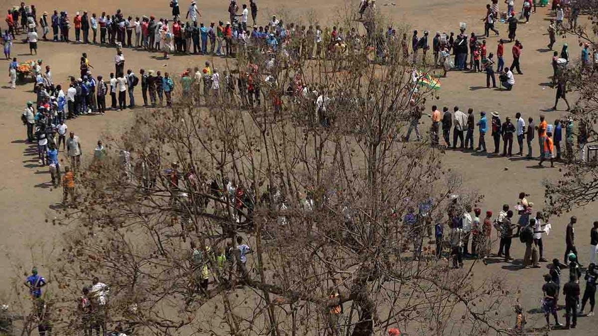 People queue at the Rufaro Stadium in Harare, Thursday, Sept. 12, 2019, where former President Robert Mugabe will lie in state for a public viewing.