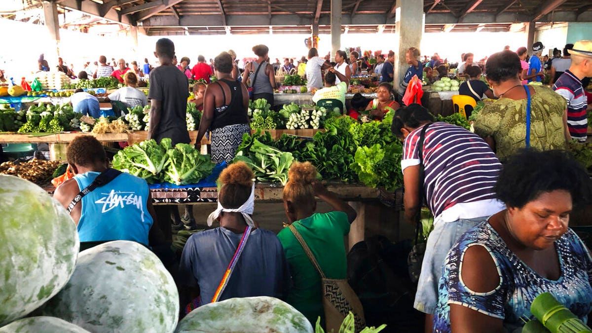 Customers shop for vegetables at the Honiara Central Market in Honiara, the capital of the Solomon Islands. 