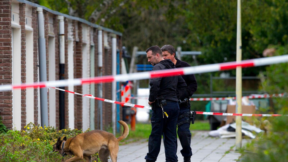 Forensic experts with a dog search for evidence in the area where a lawyer who represented a key witness in a major Dutch organized crime trial was gunned down in Amsterdam, in Amsterdam, Netherlands, Wednesday, Sept. 18, 2019. 