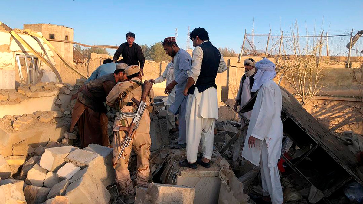 Afghan security members and people work at the site of a suicide attack in Zabul, Afghanistan, Thursday, Sept. 19, 2019. A powerful early morning suicide truck bomb devastated a hospital in southern Afghanistan on Thursday. (AP Photo/Ahmad Wali Sarhadi)