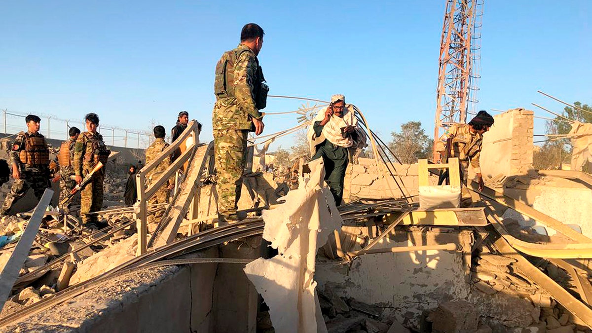 Afghan security members and people work at the site of a suicide attack in Zabul, Afghanistan, Thursday, Sept. 19, 2019. A powerful early morning suicide truck bomb devastated a hospital in southern Afghanistan on Thursday. (AP Photo/Ahmad Wali Sarhadi)