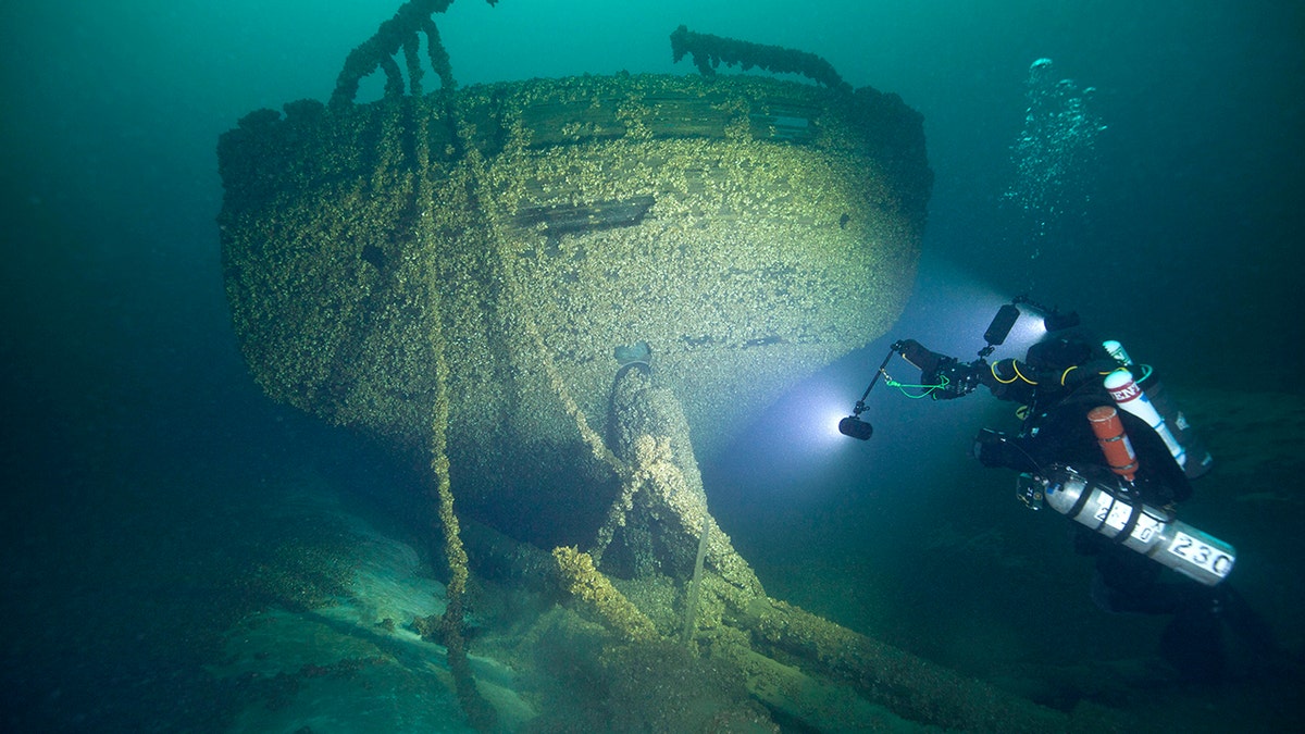 In this Aug. 24, 2019, photo provided by John Janzen, diver John Scoles maneuvers around the wreckage of the schooners Peshtigo and St. Andrews, lost in 1878 near Beaver Island in northern Lake Michigan. A group of maritime history enthusiasts led by Boyne City, Michigan diver and explorer, Bernie Hellstrom have announced the discovery of the schooners. The site was located in 2010 by Hellstrom during one of his many trips to explore the Beaver Island archipelago.
