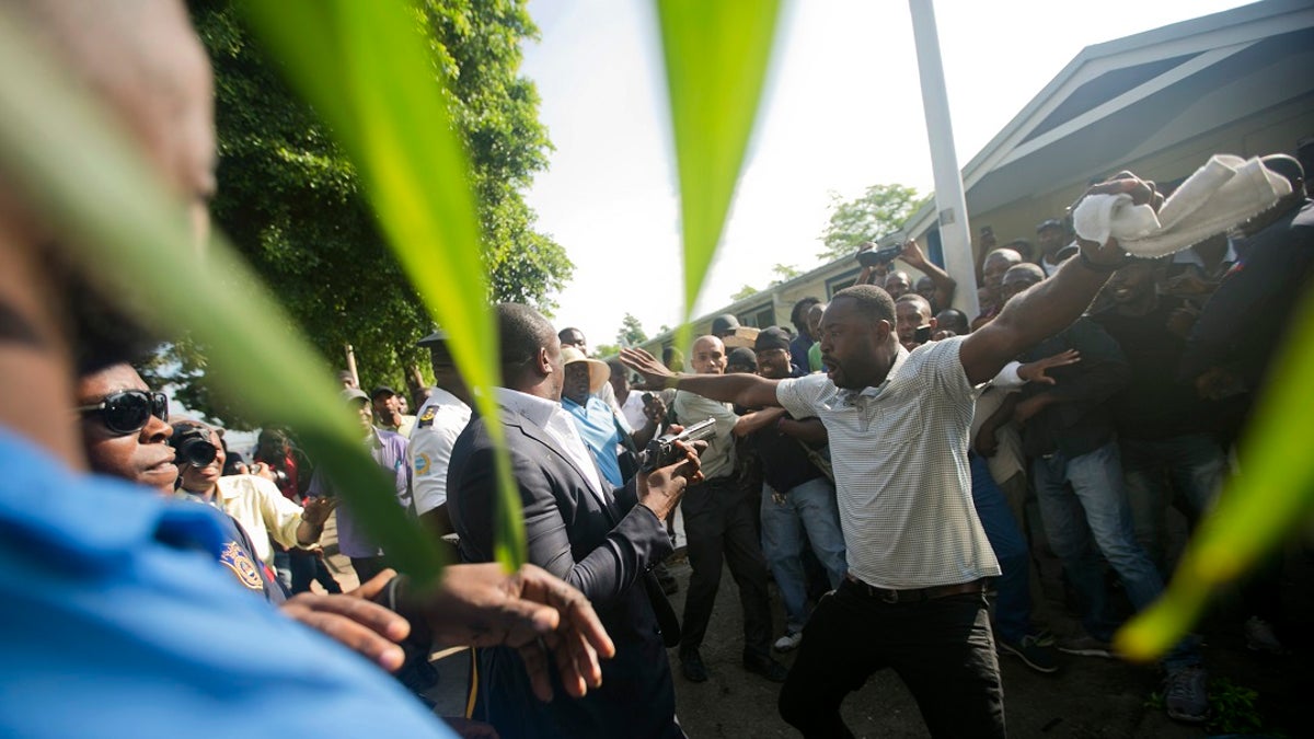 An opposition protester holds out his arms and yells, "Kill me" to ruling party Senator Willot Joseph. (AP Photo/Dieu Nalio Chery)