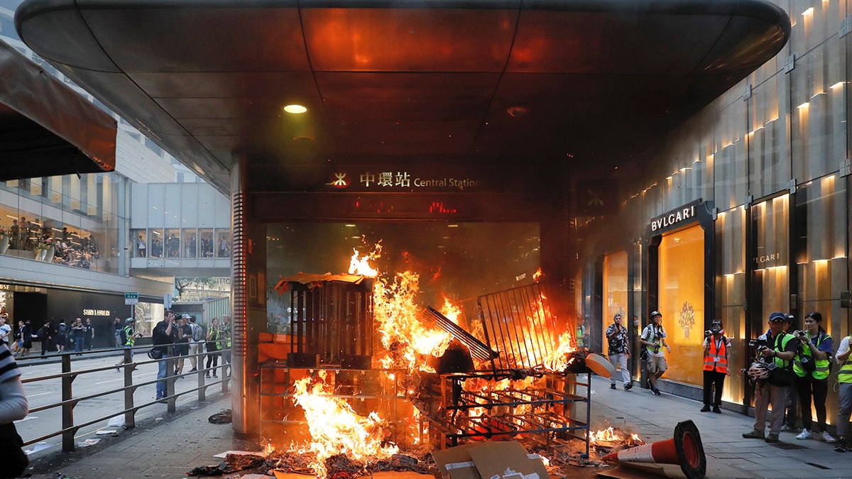 In this Sunday, Sept. 8, 2019, file photo, a fire set by protesters burns at an entrance to the Central MTR subway station in Hong Kong. Thousands of demonstrators participated in a peaceful march to the U.S. Consulate but later violence broke out in the business and retail but later after protesters vandalized a metro station and blocked traffic at a major thoroughfare, with several people detained. (AP Photo/Kin Cheung, File)