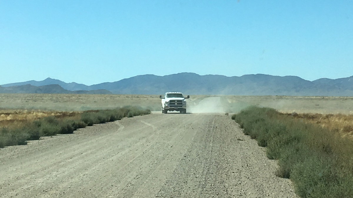 An unmarked white truck turns from a side road onto the roadway to Area 51's so-called "back gate" on Sept. 18, 2019.