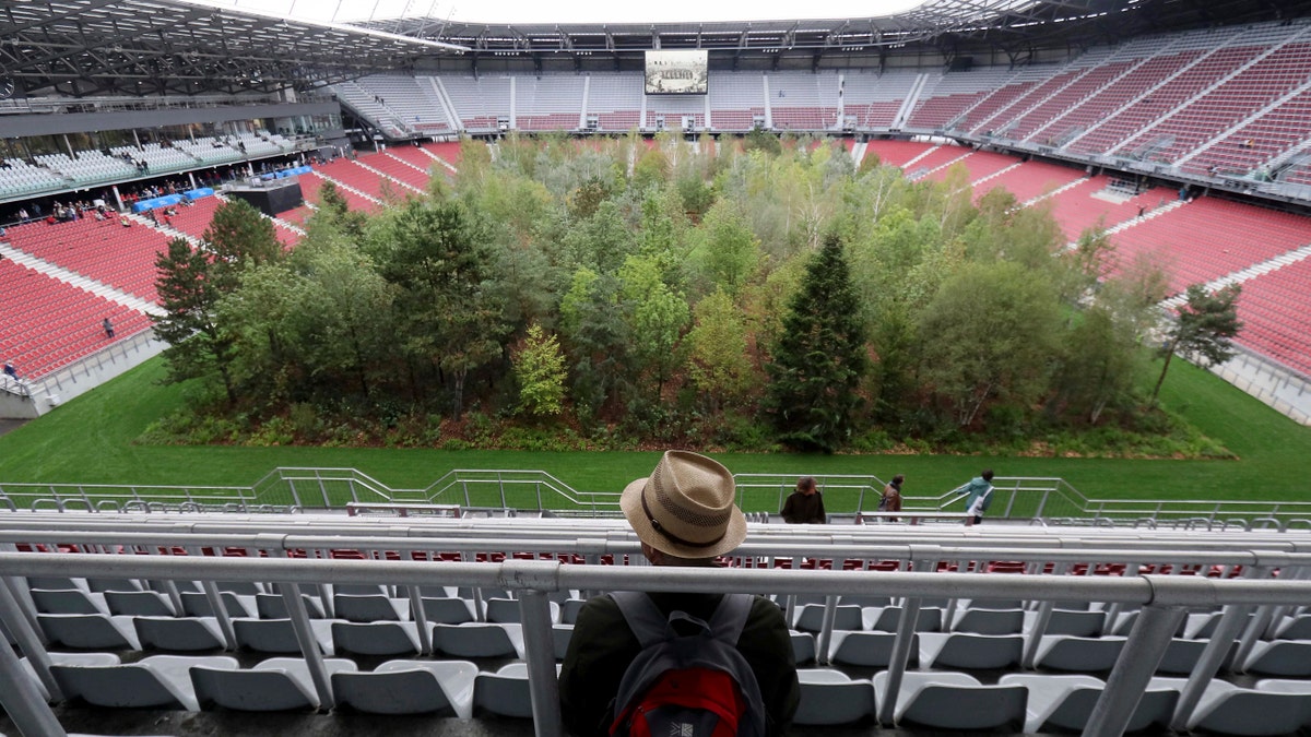 Visitors looks at the temporary art intervention by Swiss artist Klaus Littmann, FOR FOREST -The Unending Attraction of Nature, in the Woerthersee Stadium in Klagenfurt, Austria, Sunday, Sept. 8, 2019.