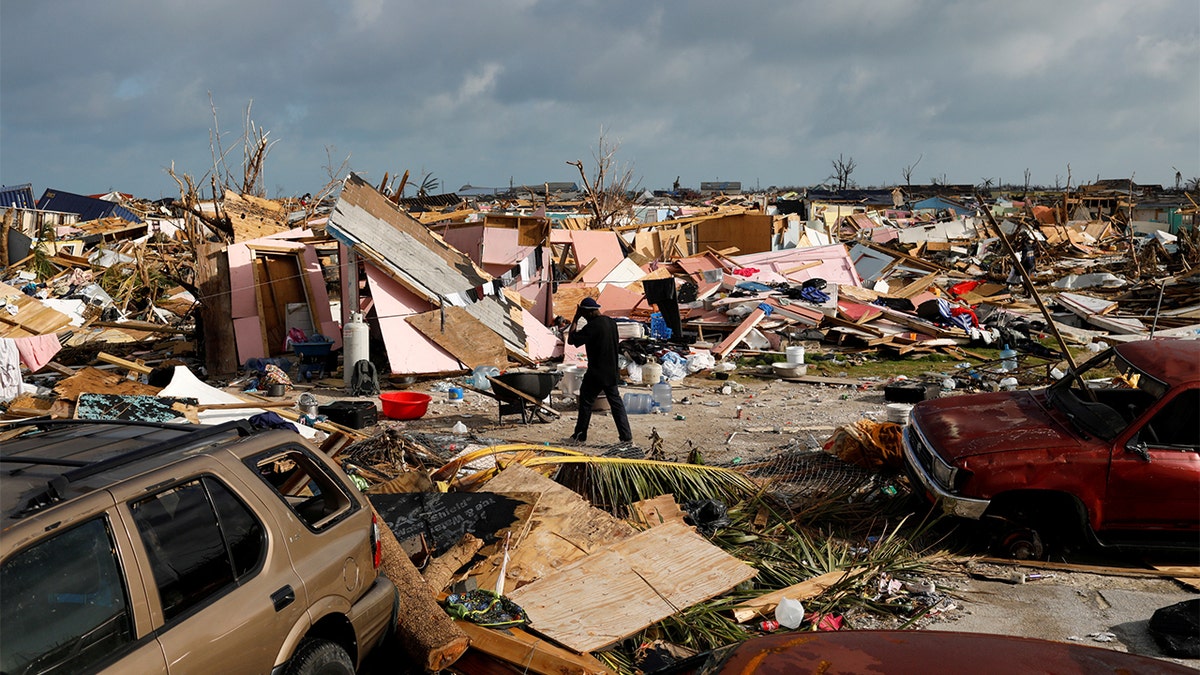 A man walks among debris at the Mudd neighborhood, devastated after Hurricane Dorian hit the Abaco Islands in Marsh Harbour, Bahamas, September 6, 2019. (REUTERS/Marco Bello)
