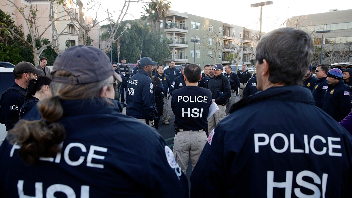 Federal agents gathering at a parking lot before raiding an upscale apartment complex linked to a birth tourism business in Irvine, Calif., in 2015.