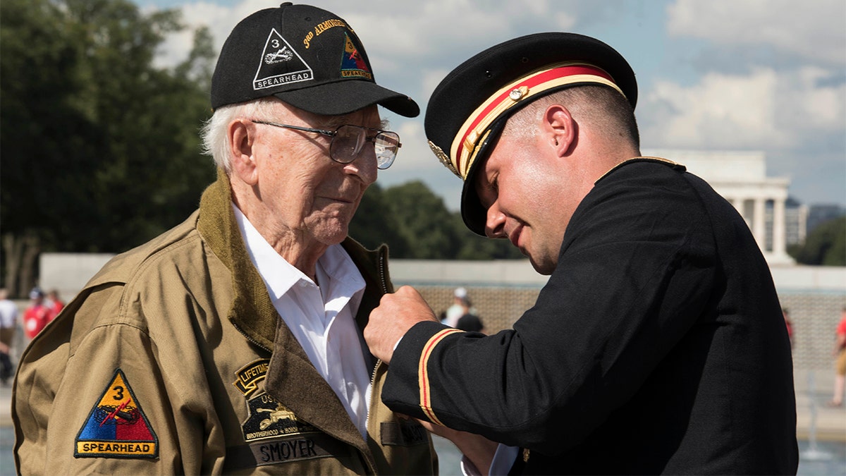 U.S. Army Major Peter Semanoff pins the Bronze Star Medal on WWII veteran Clarence Smoyer during the WWII Bronze Star Award Ceremony at the National WWII Memorial, Washington, D.C., Sept. 18, 2019. (DoD photo by U.S. Navy Petty Officer 2nd Class James K. Lee)