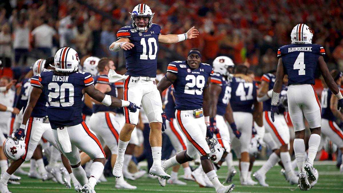 Auburn quarterback Bo Nix (10) celebrates with teammates after Auburn came from behind to defeat Oregon following an NCAA college football game, Saturday, Aug. 31, 2019, in Arlington, Texas. Auburn won 27-21. (AP Photo/Ron Jenkins)