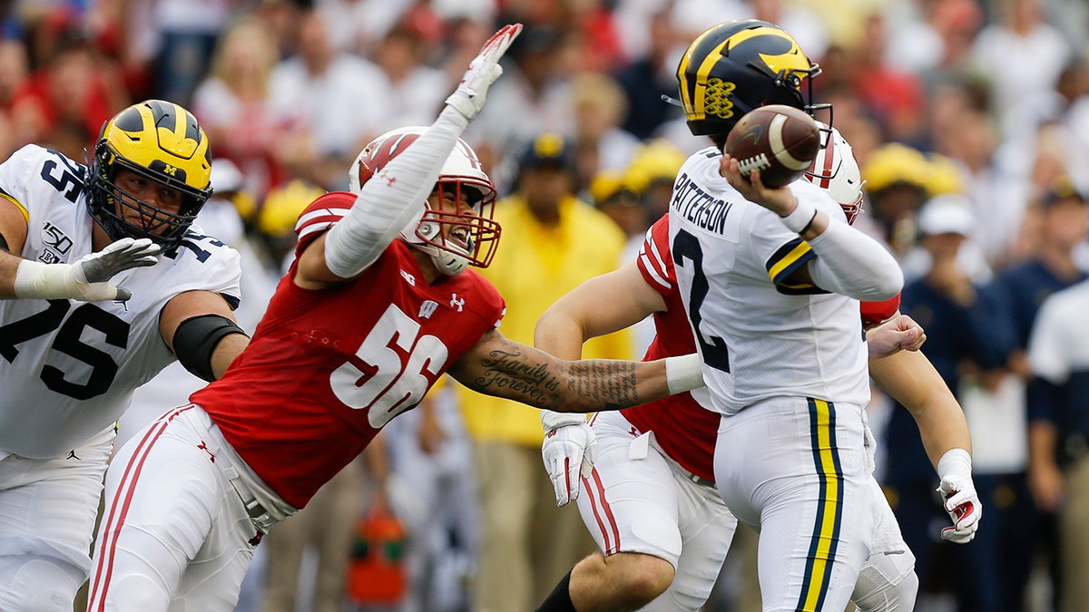 Wisconsin defensive end Rodas Johnson (56) goes after Michigan quarterback Shea Patterson (2) during the first half of an NCAA college football game Saturday, Sept. 21, 2019, in Madison, Wis. (AP Photo/Andy Manis)