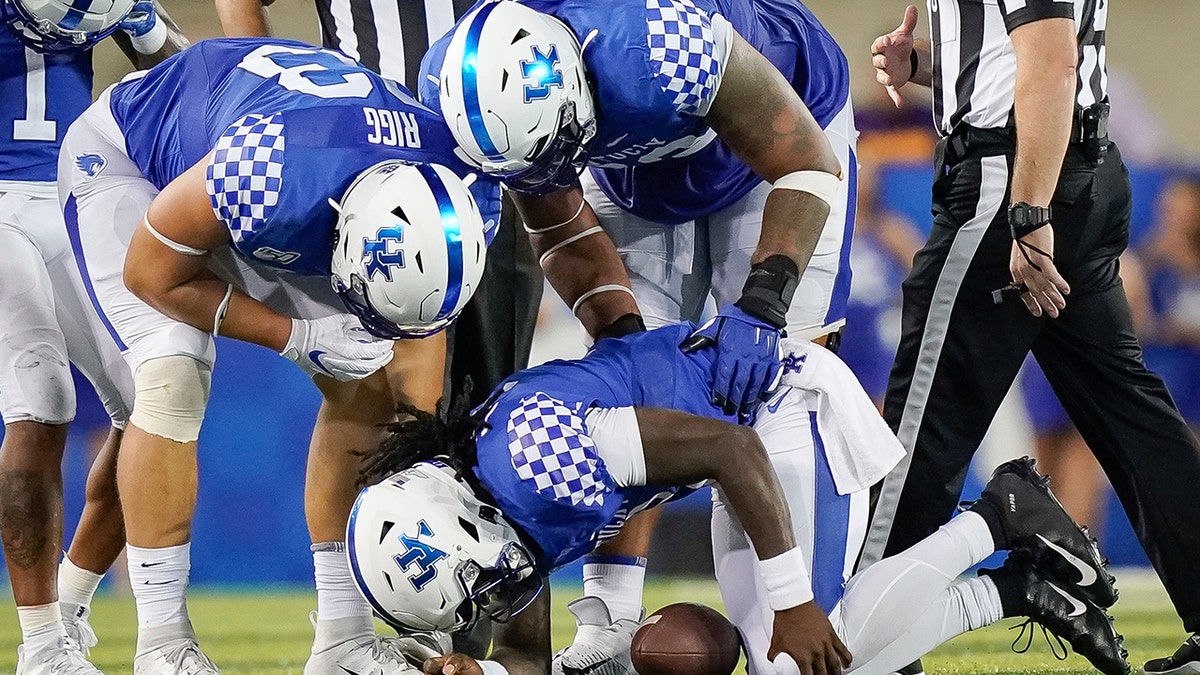 Kentucky quarterback Terry Wilson (3) is attended to by teammates after being injured on a play during the second half of an NCAA college football game between Kentucky and Eastern Michigan, Saturday, Sept. 7, 2019, in Lexington, Ky. (AP Photo/Bryan Woolston)