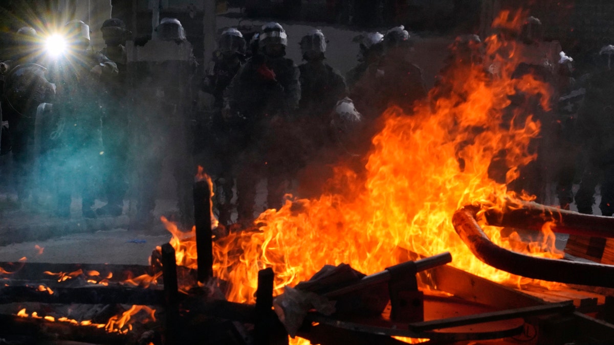 Police face a burning barricade during protests in Hong Kong on Saturday, Sept. 21, 2019. Protesters in Hong Kong burned a Chinese flag and police fired pepper spray Saturday in renewed clashes over grievances by the anti-government demonstrators. (AP Photo/Vincent Yu)