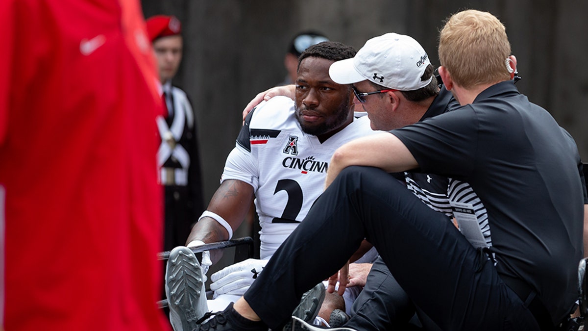 Cincinnati Bearcats safety Kyriq McDonald #26 is carted off the field after an injury during game action between the Ohio State Buckeyes and the Cincinnati Bearcats on Saturday in Columbus, Ohio.. (Photo by Adam Lacy/Icon Sportswire via Getty Images)