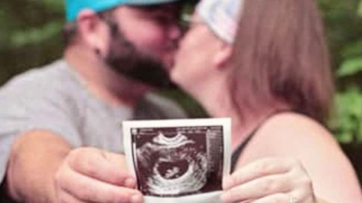 Elisha and Tyler Hessel, showing an ultrasound of their unborn daughter. 