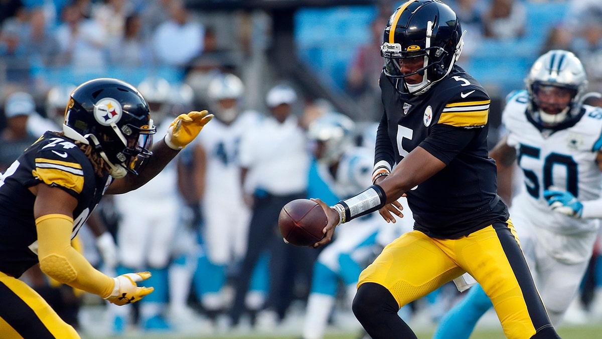 Pittsburgh Steelers quarterback Joshua Dobbs (5) hands off to running back Benny Snell (24) during the first half of an NFL preseason football game against the Carolina Panthers in Charlotte, N.C., Thursday, Aug. 29, 2019. (AP Photo/Brian Blanco)