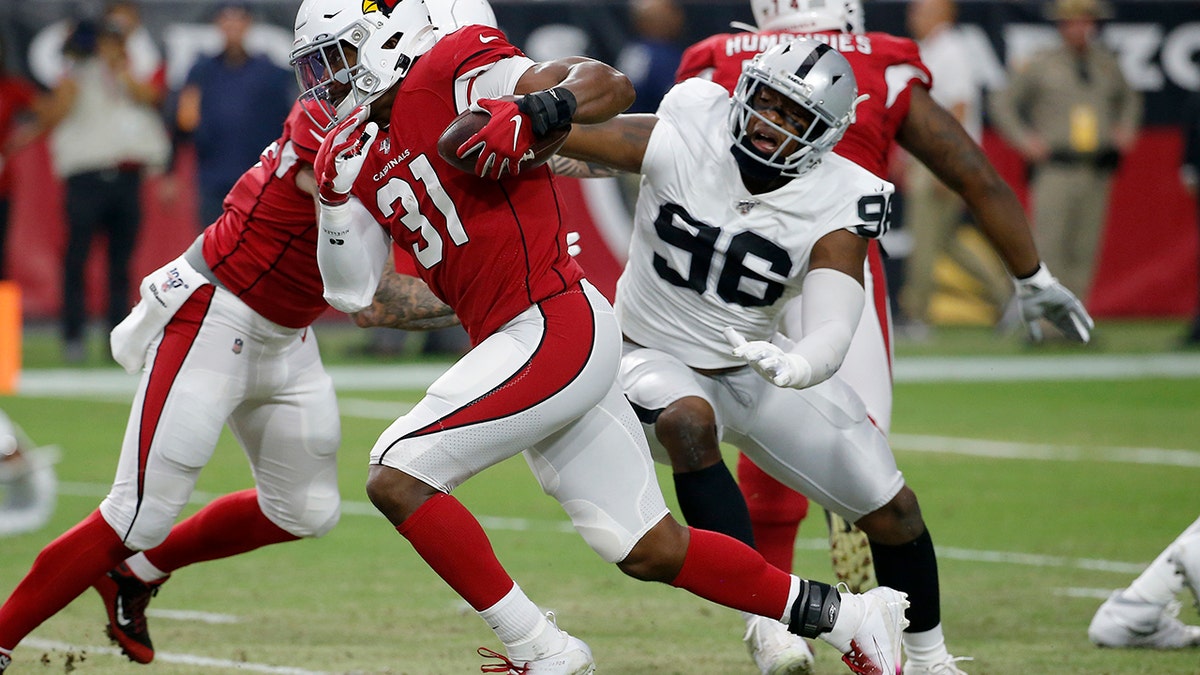 FILE - In this Aug. 15, 2019, file photo, Arizona Cardinals running back David Johnson (31) runs as Oakland Raiders defensive end Clelin Ferrell (96) defends during the first half of an an NFL preseason football game in Glendale, Ariz. (AP Photo/Rick Scuteri, File)