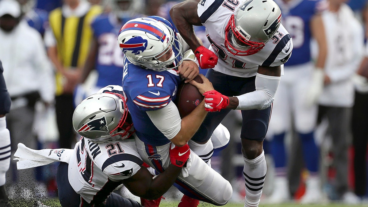 New England Patriots defenders Jonathan Jones (31) and New England Patriots Duron Harmon (21) tackle Buffalo Bills quarterback Josh Allen (17) in the second half of an NFL football game, Sunday, Sept. 29, 2019, in Orchard Park, N.Y. Allen left the field after the play. (AP Photo/Ron Schwane)