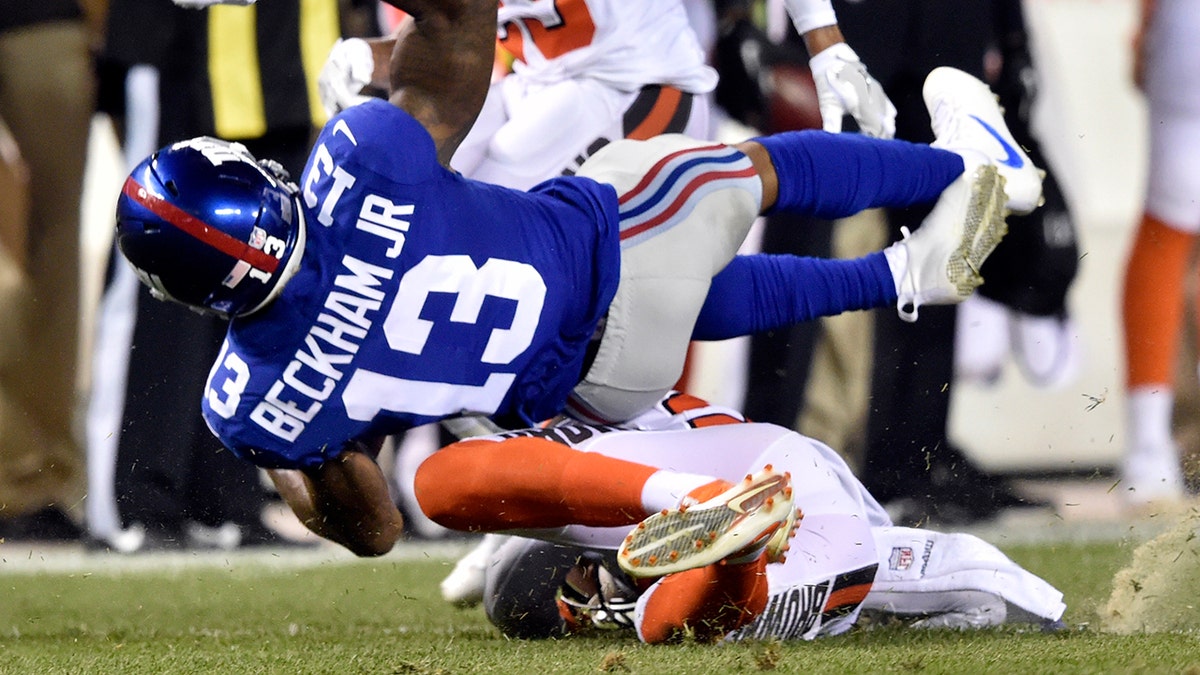 FILE - In this Aug. 21, 2017, file photo, New York Giants wide receiver Odell Beckham (13) is tackled by Cleveland Browns strong safety Briean Boddy-Calhoun in the first half of an NFL preseason football game in Cleveland. (AP Photo/David Richard, File)