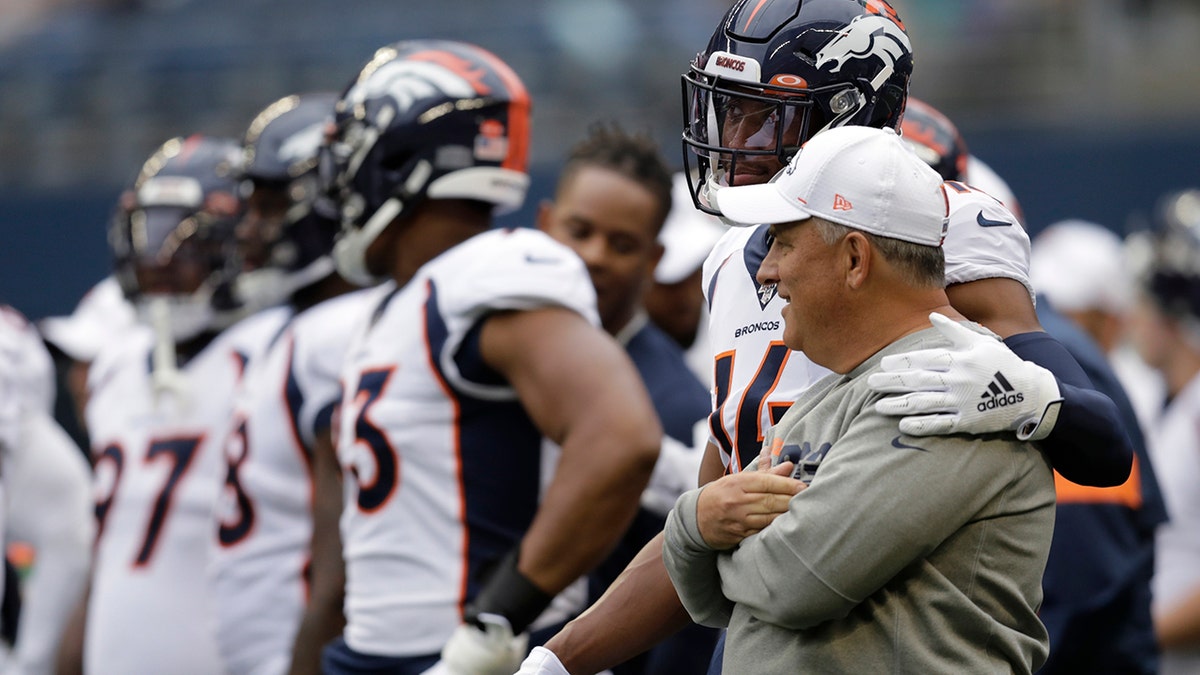 In this Aug. 8, 2019, file photo, Denver Broncos wide receiver Courtland Sutton (14) stands with coach Vic Fangio, right, before the team's NFL football preseason game against the Seattle Seahawks in Seattle. (AP Photo/Stephen Brashear, File)