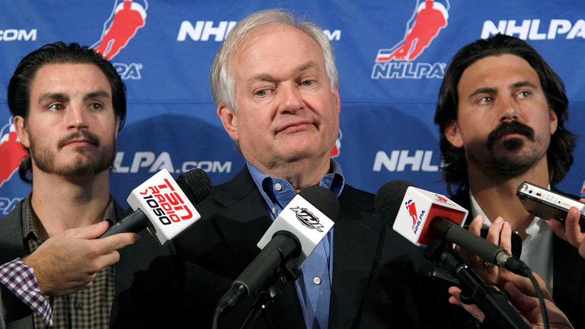 FILE - In this Sept. 12, 2012, file photo, National Hockey League Players' Association executive director Donald Fehr, center, is joined by players George Parros , left, and Kevin Westgath after meeting with NHL officials in New York. The NHLPA announces its decision whether to terminate the current collective bargaining agreement and set the clock ticking toward another potential work stoppage in 2020. (AP Photo/Mary Altaffer, File)