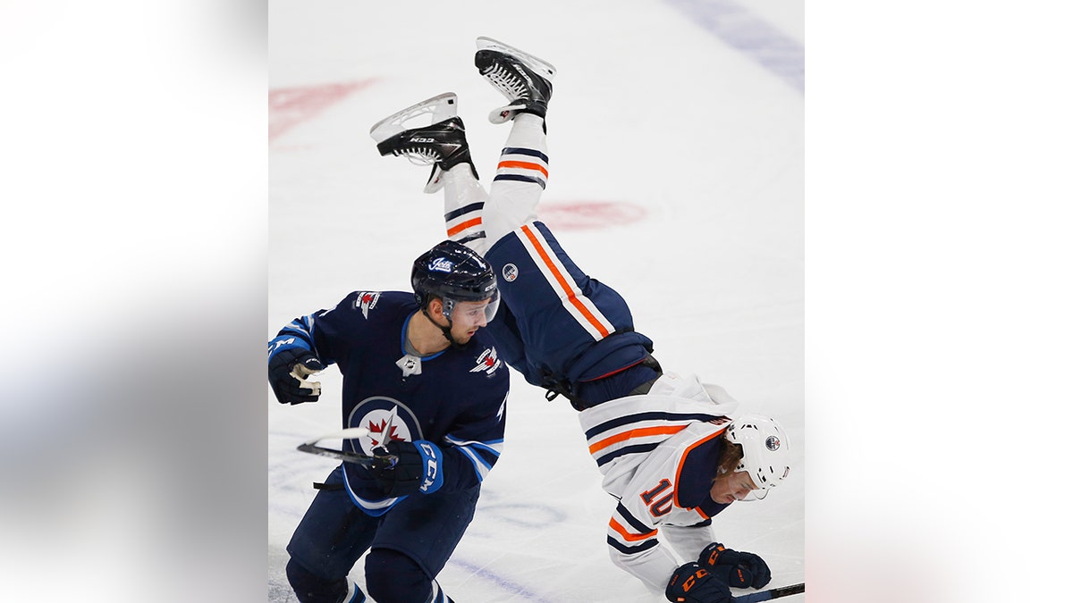 Winnipeg Jets' Neal Pionk sends Edmonton Oilers' Joakim Nygard airborne  with open-ice hit