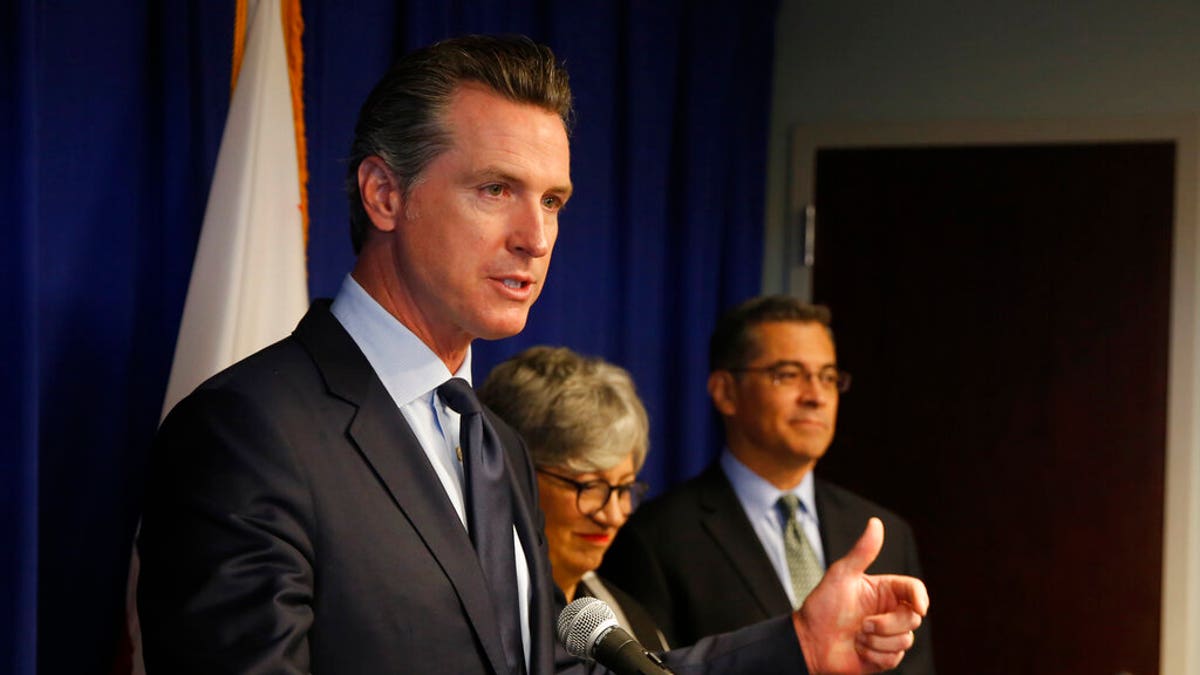 Gov. Gavin Newsom, left, flanked by California Air Resources Board Chair Mary Nichols and California Attorney General Xavier Becerra. (AP Photo/Rich Pedroncelli)
