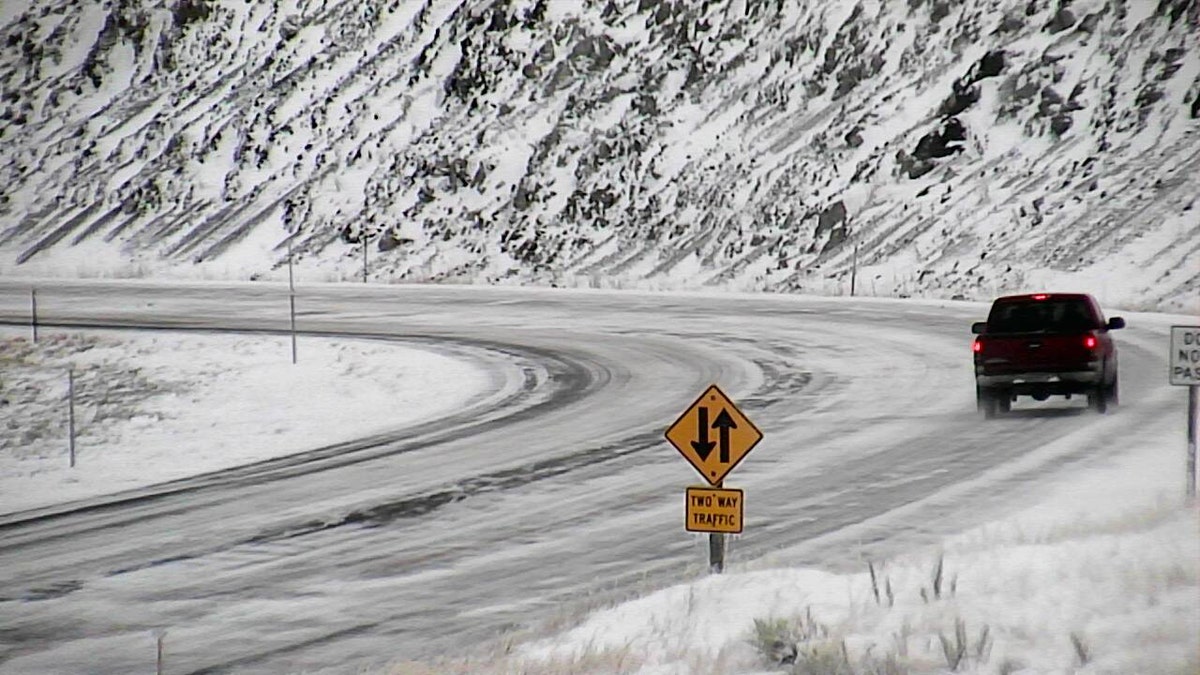 A motorist travels along U.S. 287 near Norris, Mont. during a snowstorm on Sunday.