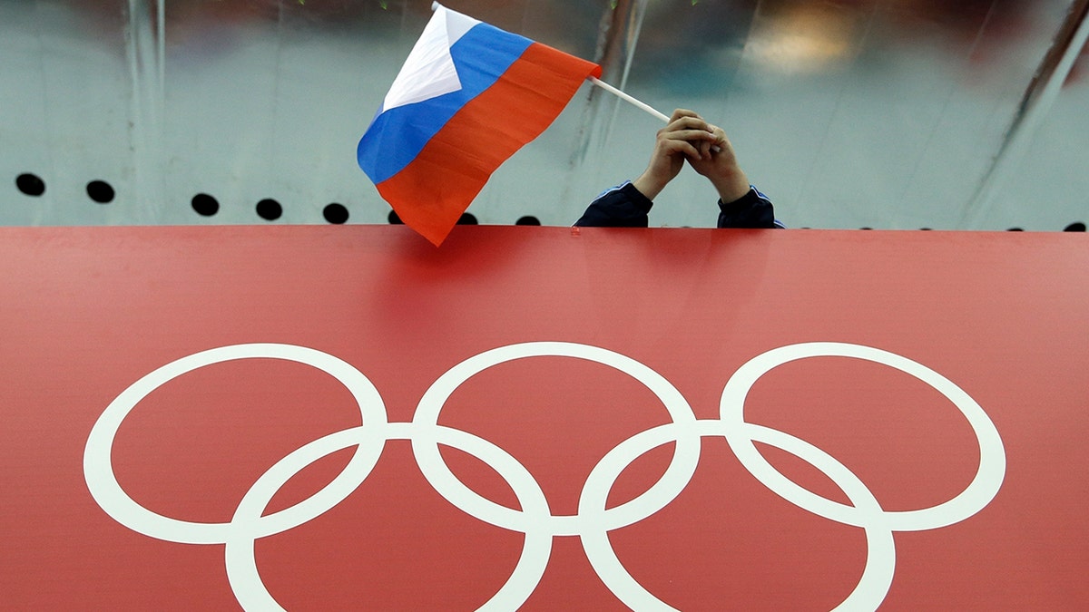 FILE - In this Feb. 18, 2014 file photo, a Russian skating fan holds the country's national flag over the Olympic rings before the men's 10,000-meter speedskating race at Adler Arena Skating Center during the Winter Olympics in Sochi, Russia. A person familiar with the case tells The Associated Press that Russia's anti-doping agency could face suspension again based on information indicating data from the Moscow drug-testing lab had been manipulated before being delivered to the World Anti-Doping Agency earlier this year. (AP Photo/David J. Phillip, File)
