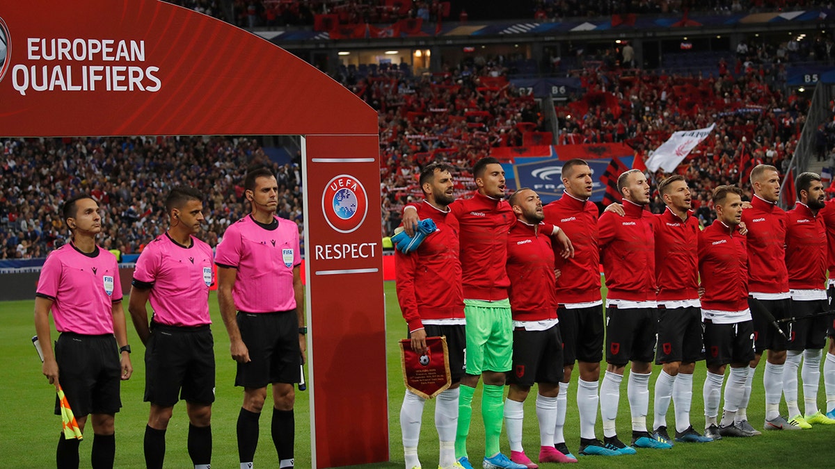 Referees and Albania's soccer team stand during Albania's national anthem, after the wrong one was playing, during of the Euro 2020 group H qualifying soccer match between France and Albania at the Stade de France in Saint Denis, north of Paris, France, Saturday, Sept. 7, 2019. (AP Photo/Christophe Ena)