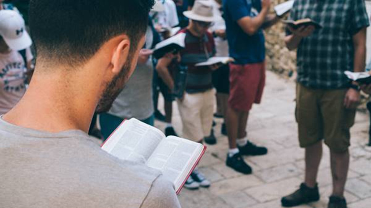 Students read their Bibles at a holy site in Israel with the Passages Israel trip.