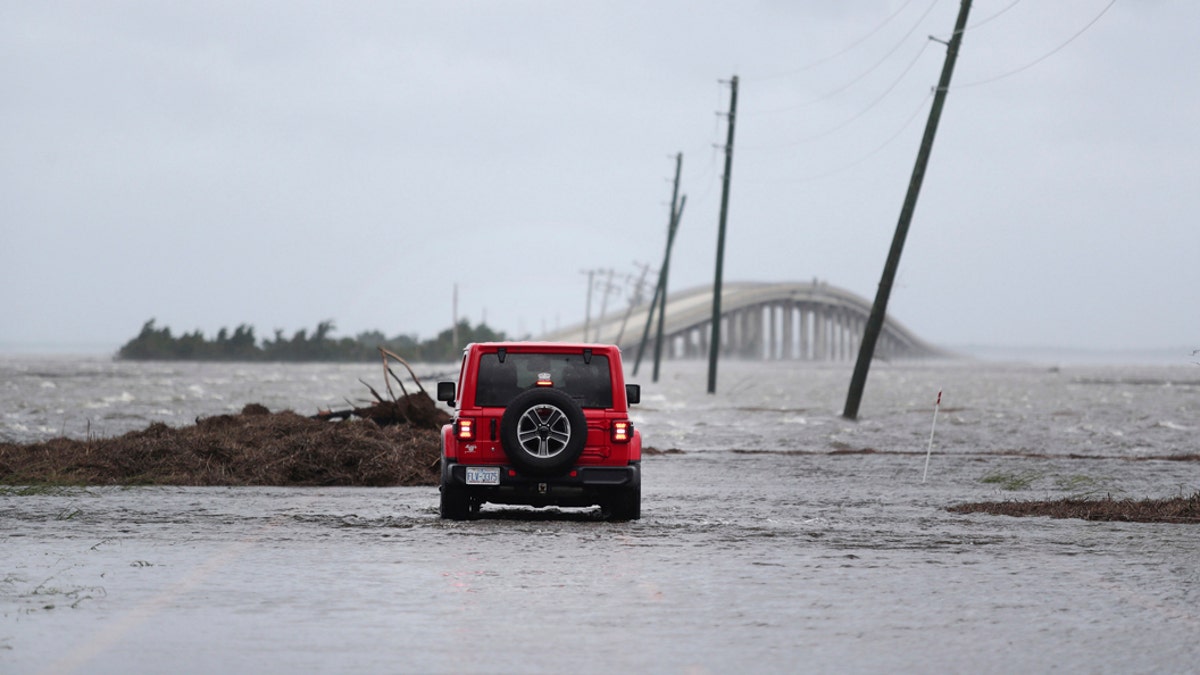 FILE - In this Friday, Sept. 6, 2019 file photo, storm surge from Hurricane Dorian blocks Cedar Island off from the mainland on NC 12 in Carteret County, N.C., after Hurricane Dorian passed the coast. A special United Nations-affiliated oceans and ice report released on Wednesday, Sept. 24, 2019 projects three feet of rising seas by the end of the century, much fewer fish, weakening ocean currents, even less snow and ice, and nastier hurricanes, caused by climate change. (AP Photo/Tom Copeland)