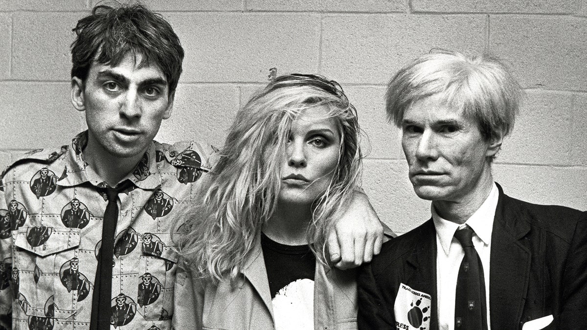 Chris Stein, Debbie Harry, and Andy Warhol pose ahead of a Blondie concert at the Meadowlands in New Jersey in August 1982.