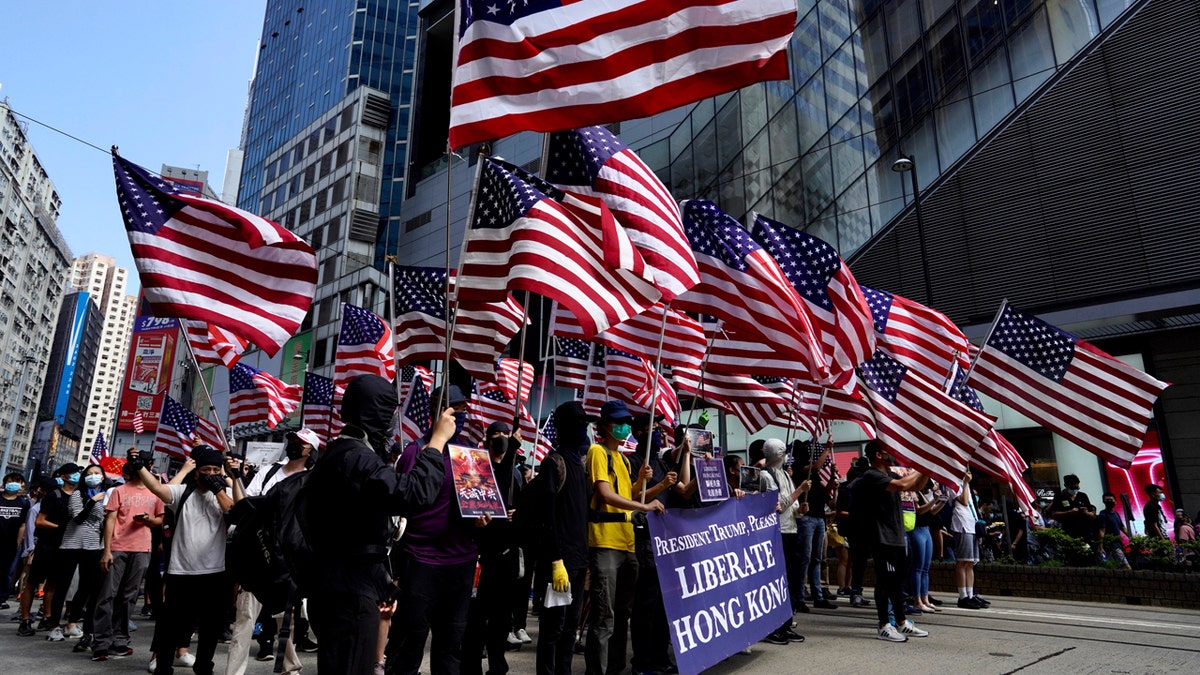Protesters carry U.S. flags during a rally in Hong Kong, Sunday, Sept. 15, 2019.