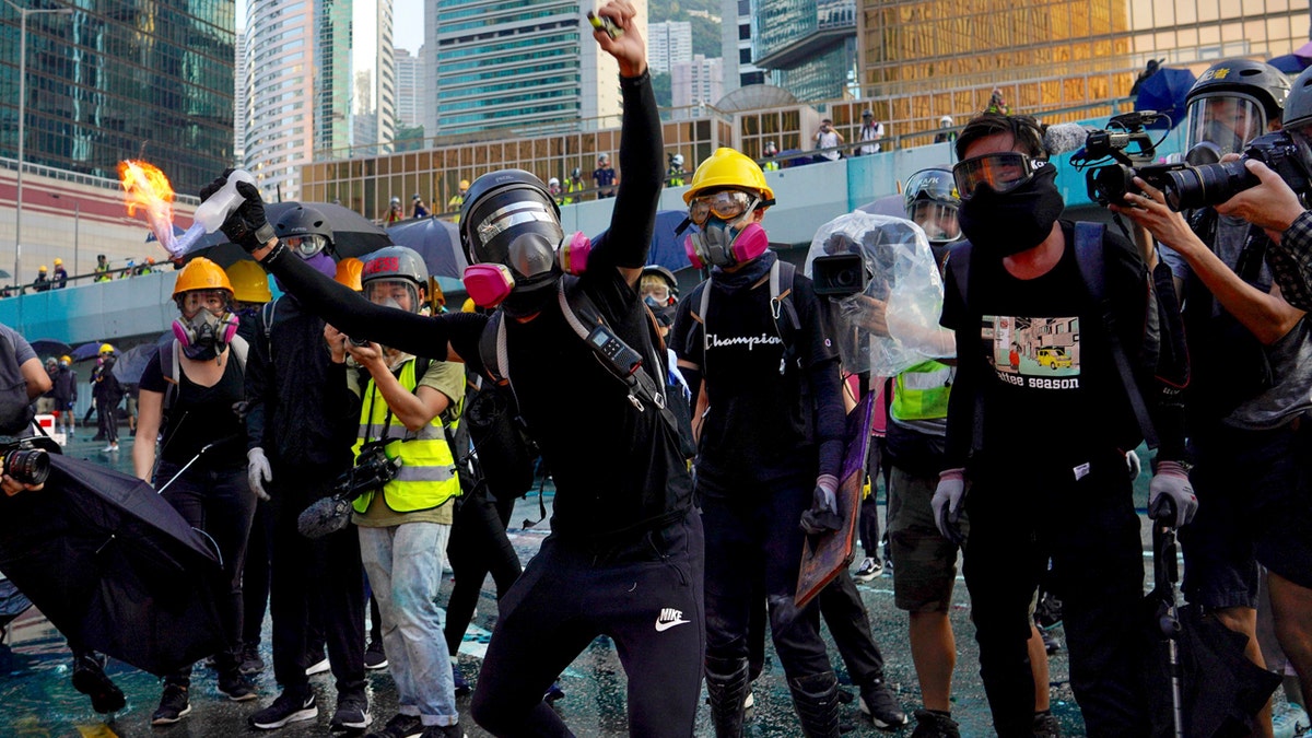 An anti-government protester throws a Molotov cocktail during a demonstration near Central Government Complex in Hong Kong, Sunday, Sept. 15, 2019.