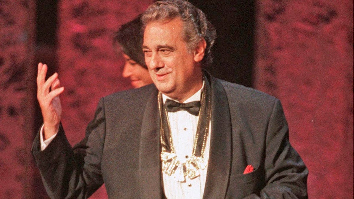 In this Tuesday, Sept. 14, 1999 file photo, Placido Domingo acknowledges the audience after receiving the 1999 Hispanic Heritage Award at the John F. Kennedy Center for the Performing Arts in Washington. An evening before a performance of “Le Cid,” part of the Washington Opera’s 1999-2000 season, opera singer Angela Turner Wilson said she and Domingo were having their makeup done together when he rose from his chair, stood behind her and put his hands on her shoulders. As she looked at him in the mirror, he suddenly slipped his hands under her bra straps, she said, then reached down into her robe and grabbed her bare breast. 
