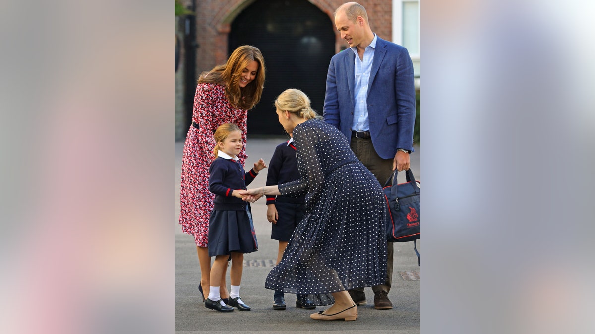 Britain's Princess Charlotte of Cambridge, accompanied by her father, Britain's Prince William, Duke of Cambridge, her mother, Britain's Catherine, Duchess of Cambridge, is greeted by Helen Haslem, head of the lower school (CR) on her arrival for her first day of school at Thomas's Battersea in London on September 5, 2019. (Photo by Aaron Chown / POOL / AFP)        (Photo credit should read AARON CHOWN/AFP/Getty Images)