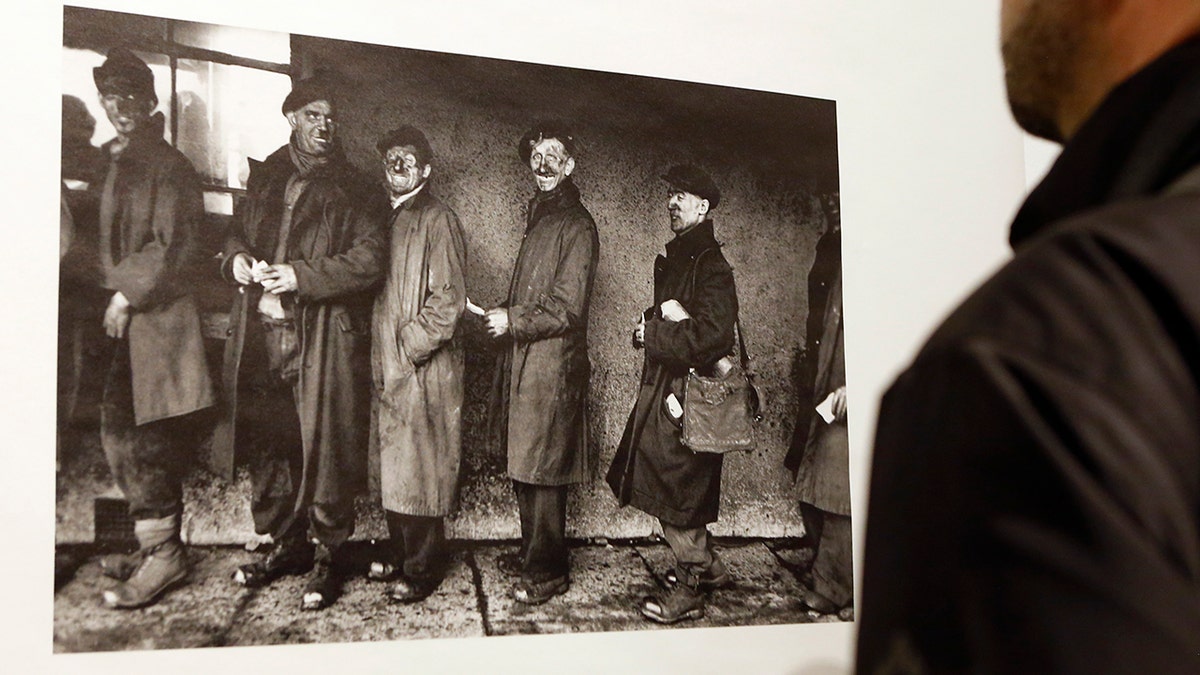 In this Jan. 28, 2016 file photo, a man looks at a photograph by Robert Frank at the opening of the exhibition featuring Frank's work, "Robert Frank: Books and Films, 1947–2016," at New York University's Tisch School of the Arts in New York.