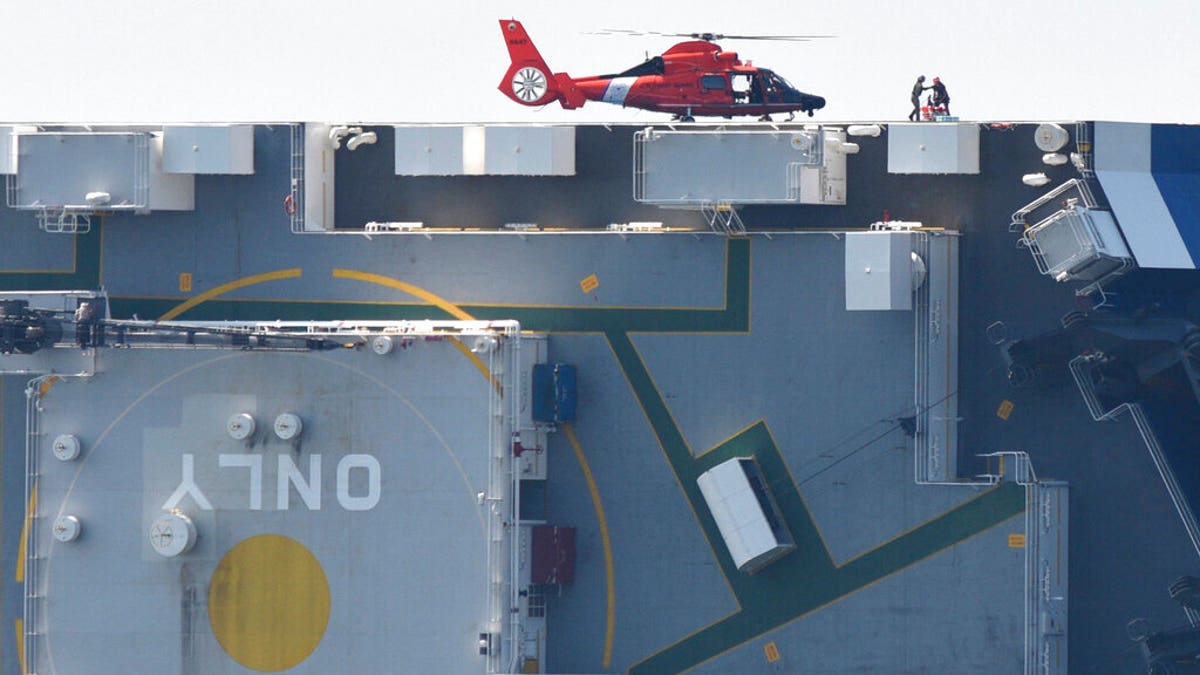 Members of the U.S. Coast Guard unload supplies from a Coast Guard helicopter from the side of the cargo ship Golden Ray, Monday(Bobby Haven/The Brunswick News via AP)