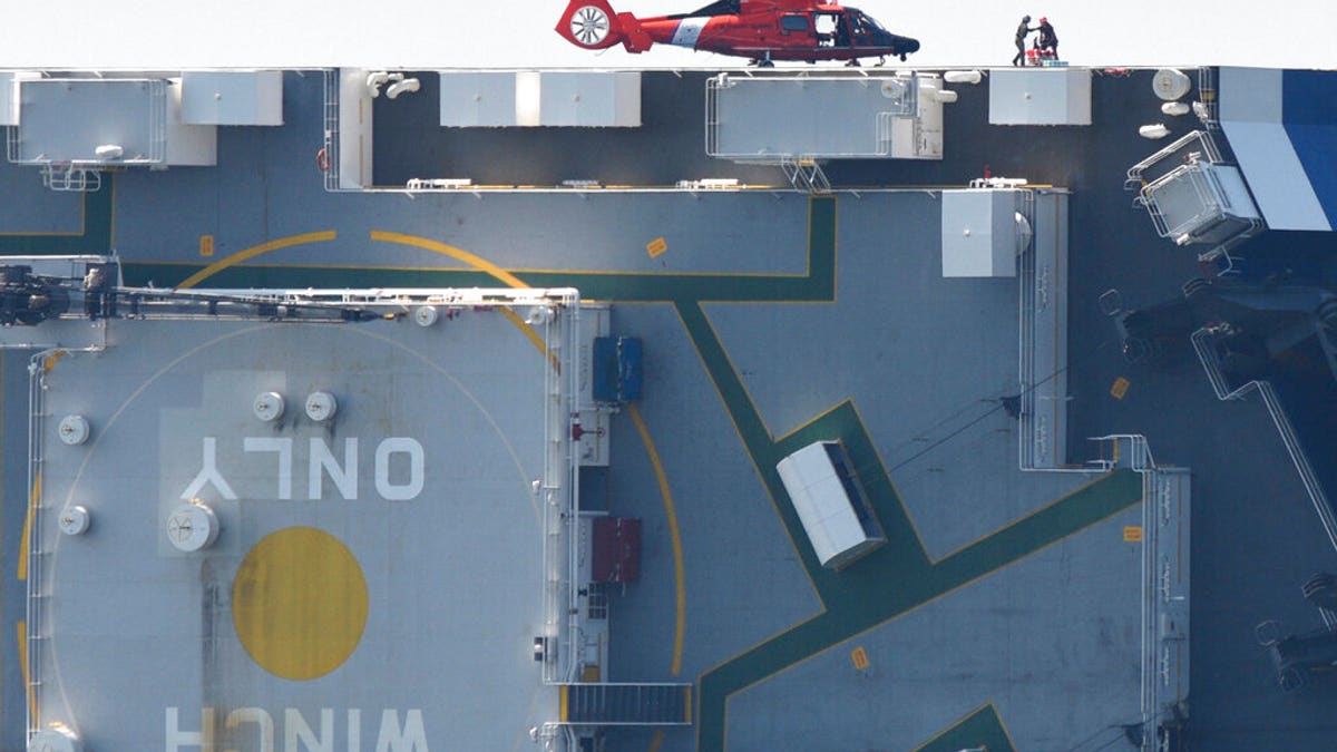 Members of the U.S. Coast Guard unload supplies from a Coast Guard helicopter from the side of the cargo ship Golden Ray, Monday(Bobby Haven/The Brunswick News via AP)