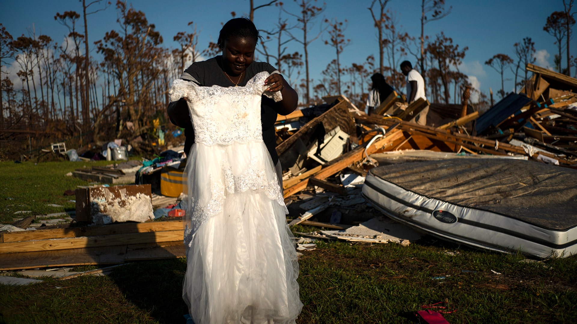 Synopsis Reckley holds up the dress her niece wore as a flower girl at her wedding, as she goes through valuables in the rubble of her home destroyed by Hurricane Dorian in Rocky Creek East End, Grand Bahama, Bahamas, Sept. 8, 2019. 