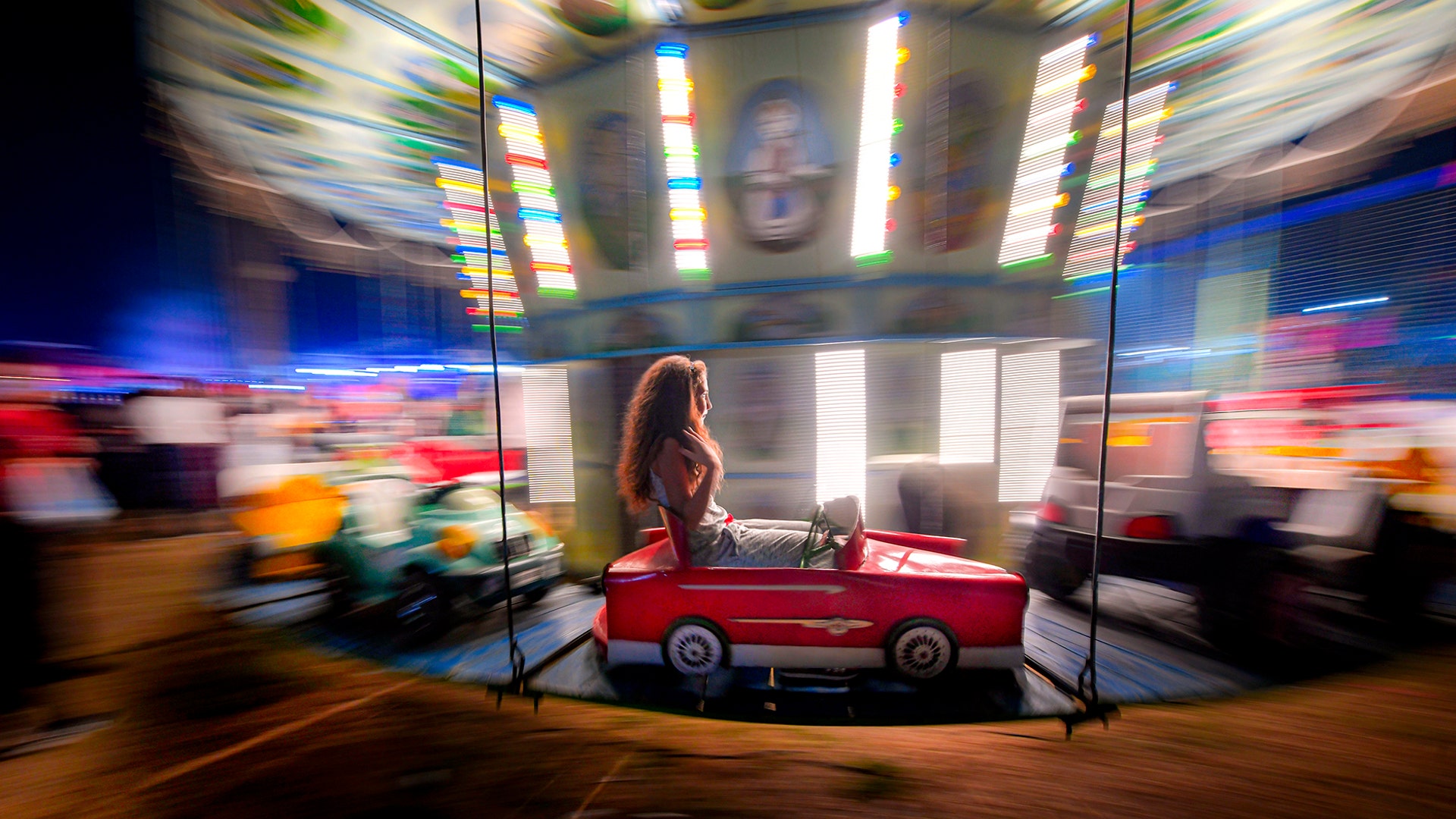 A girl rides on a merry go round at an autumn fair in Rosiorii de Vede, Romania, Sept. 7, 2019. 