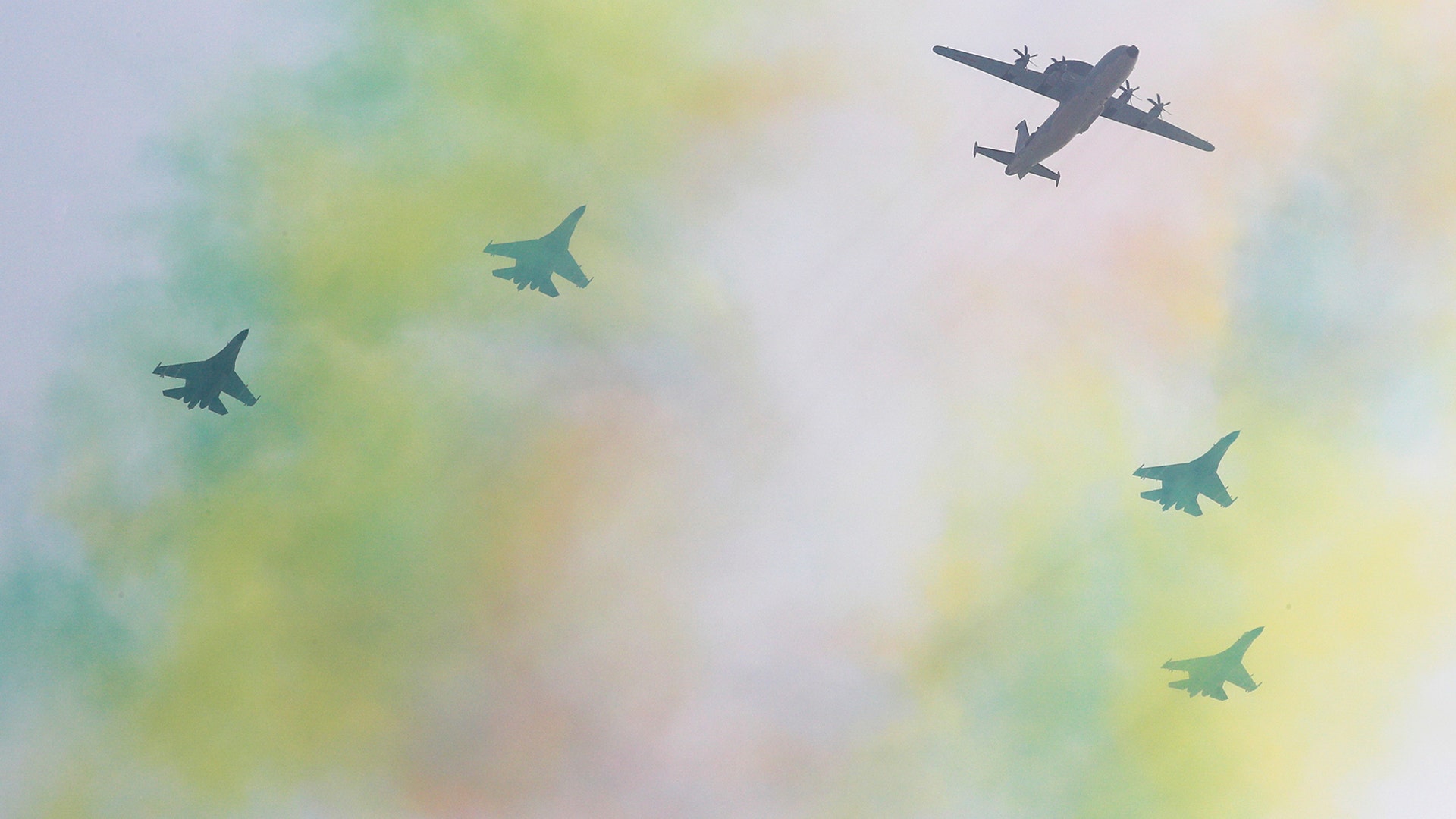 Chinese military planes fly in formation over a trail of colored smoke in Beijing, Sept. 22, 2019. 