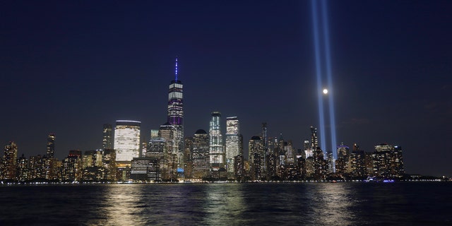 The moon passes through the annual Tribute in Light illuminated on the skyline of lower Manhattan on the 18th anniversary of the 9/11 attacks in New York City on Sept. 11, 2019 as seen from Jersey City, New Jersey. (Photo by Gary Hershorn/Getty Images)