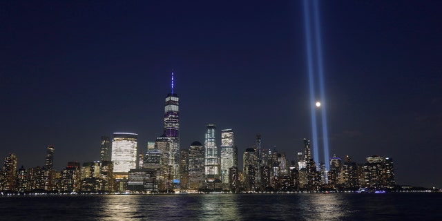 The moon passes through the annual Tribute in Light illuminated on the skyline of lower Manhattan on the 18th anniversary of the 9/11 attacks in New York City on Sept. 11, 2019 as seen from Jersey City, New Jersey. (Photo by Gary Hershorn/Getty Images)