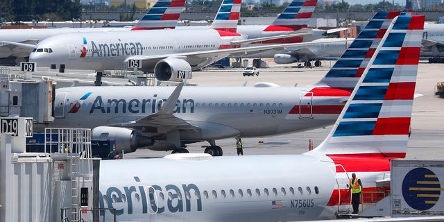 In this April 24, photo, American Airlines aircraft are shown parked at their gates at Miami International Airport in Miami.  (AP Photo/Wilfredo Lee, File)