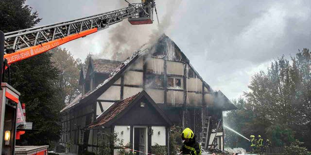 Firefighters extinguish a fire in a house in Muenster, Germany, Wednesday, Sept. 18, 2019. Two women and a police officer where injured by an explosion inside the house. (Bernd Thissen/dpa via AP)