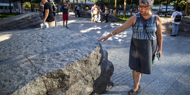 A visitor touches one of the granite slabs at the 9/11 Memorial Glade in New York City. When the names of nearly 3,000 Sept. 11 victims are read aloud today at the World Trade Center, a half-dozen stacks of stone will quietly salute an untold number of people who aren’t on the list. (AP)