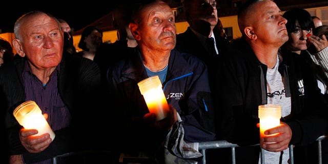 Spectators hold candles in their hands at the memorial service during ceremony marking 80th anniversary of World War II start at the exact place and time when Nazi Germany dropped its first bombs in the war, in Wielun, Poland, Sunday, Sept. 1, 2019. Observances in Warsaw will be attended by U.S. Vice President Mike Pence, in place of invited President Donald Trump.(AP Photo/Czarek Sokolowski)