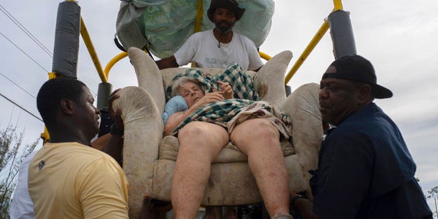 Sitting in her home's lounger, Virginia Mosvold, 84, is lowered from a truck by volunteers after being rescued from her flooded home on Ol' Freetown Farm farm in the aftermath of Hurricane Dorian before being taken to the hospital on the outskirts of Freeport, Bahamas, Wednesday, Sept. 4, 2019. (Associated Press)